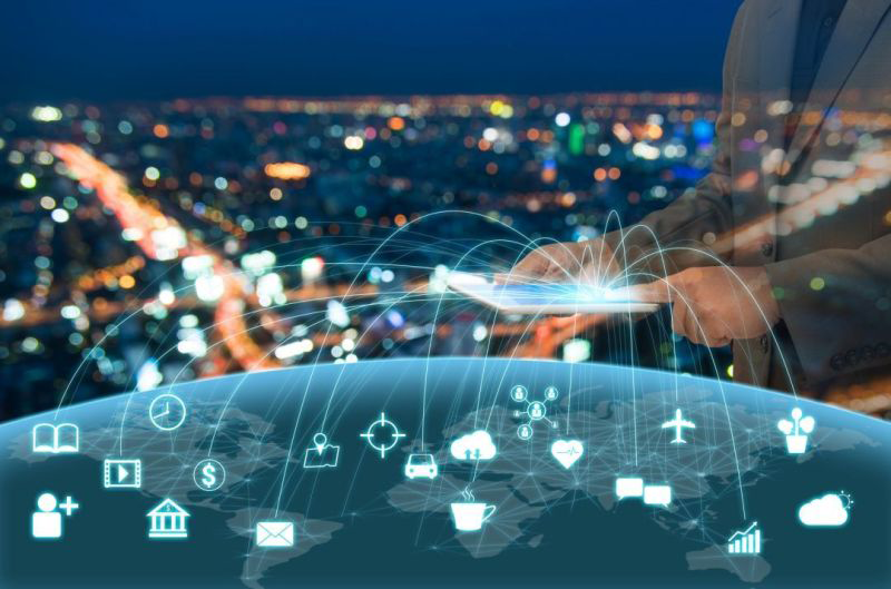 Bild der Erde vor dem Hintergrund einer Skyline, auf dem die digitale Vernetzung mit verschiedenen Icons dargestellt wird.